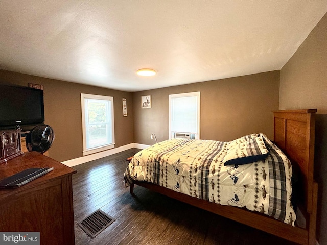 bedroom with dark hardwood / wood-style flooring and cooling unit