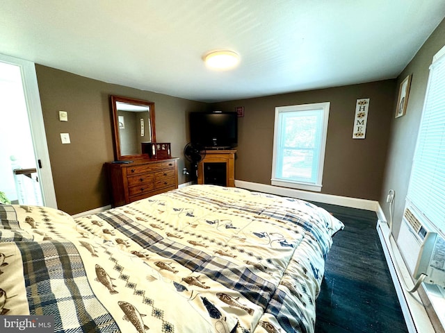 bedroom featuring dark wood-type flooring and a baseboard heating unit