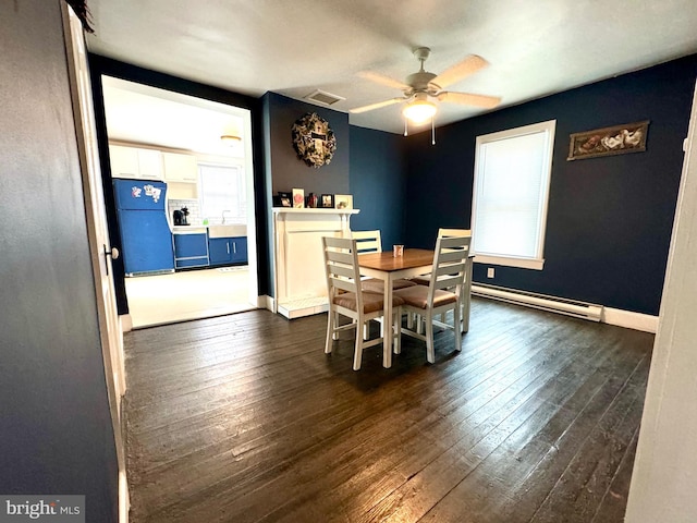 dining room featuring ceiling fan, dark hardwood / wood-style flooring, and a baseboard heating unit