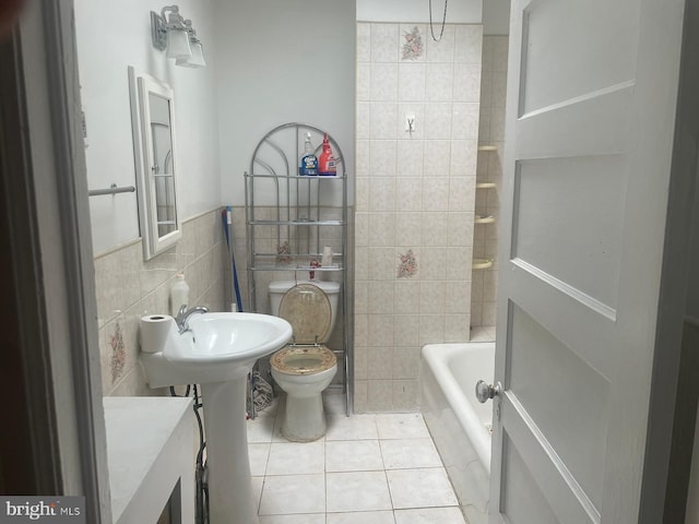 bathroom with tile patterned floors, toilet,  shower combination, and tile walls