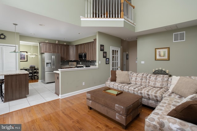 living room featuring a high ceiling and light hardwood / wood-style flooring