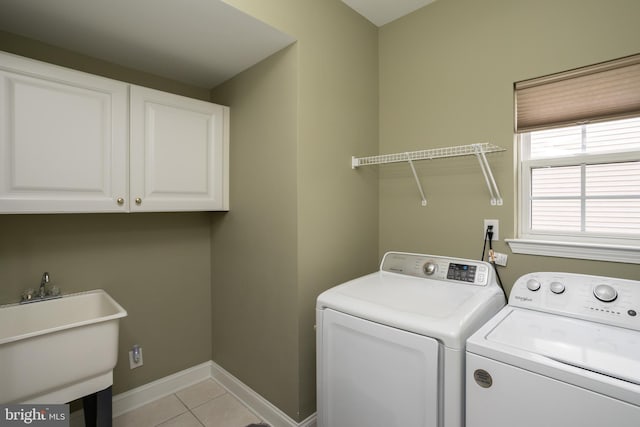 laundry room with cabinets, sink, washing machine and dryer, and light tile patterned floors