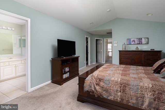 bedroom featuring ensuite bathroom, lofted ceiling, sink, and light colored carpet