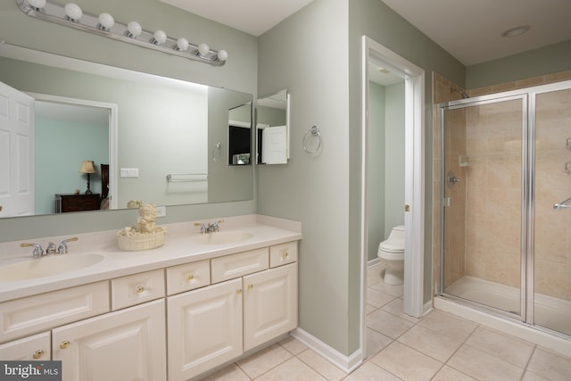 bathroom with tile patterned floors, toilet, a shower with door, and vanity