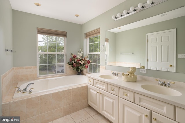 bathroom featuring tile patterned floors, tiled bath, and vanity