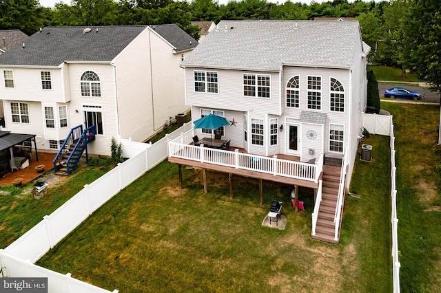 back of property with a wooden deck, central AC unit, and a lawn