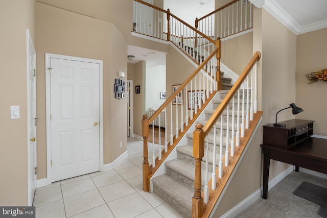 staircase featuring crown molding and tile patterned floors