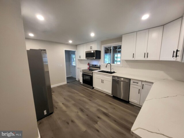 kitchen featuring sink, appliances with stainless steel finishes, dark hardwood / wood-style floors, and white cabinetry