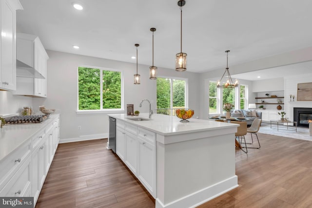 kitchen with sink, a kitchen island with sink, white cabinetry, and appliances with stainless steel finishes