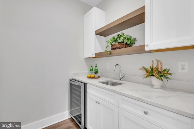 bar featuring white cabinetry, sink, dark wood-type flooring, light stone counters, and wine cooler