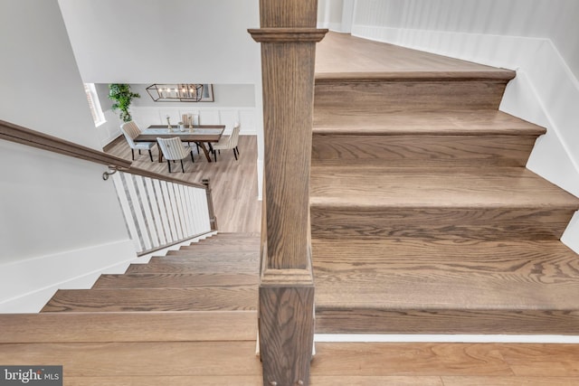 stairs with a notable chandelier