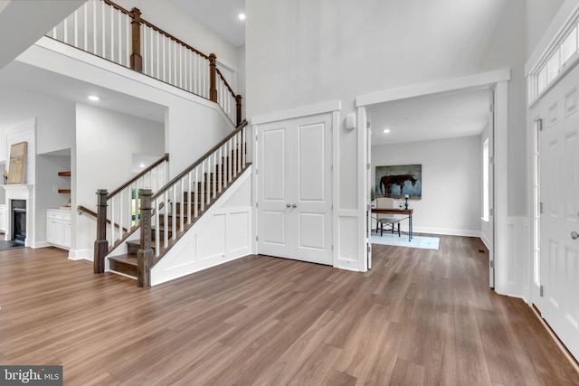 entryway featuring a towering ceiling and wood-type flooring