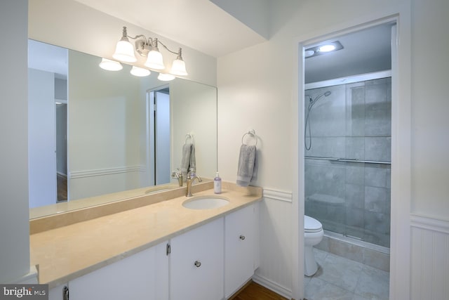 bathroom with a stall shower, vanity, toilet, and tile patterned floors