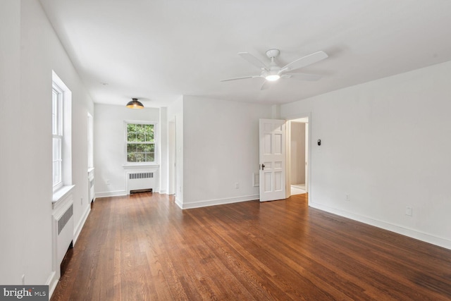 spare room featuring dark hardwood / wood-style flooring, radiator heating unit, and ceiling fan