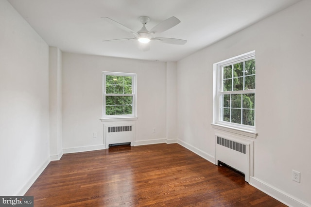 unfurnished room featuring radiator heating unit, ceiling fan, and dark hardwood / wood-style floors