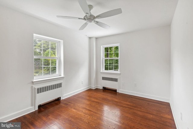 spare room featuring radiator, ceiling fan, and dark wood-type flooring