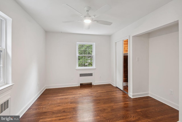 unfurnished bedroom featuring ceiling fan, radiator, and dark hardwood / wood-style flooring