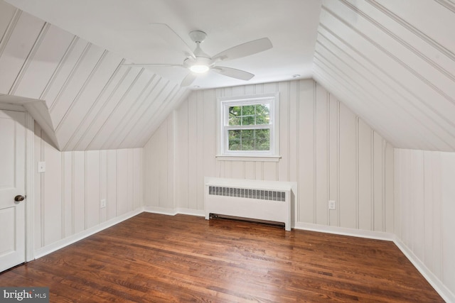 additional living space with radiator, vaulted ceiling, ceiling fan, and dark hardwood / wood-style flooring