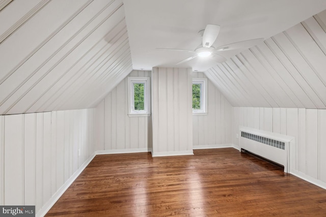 additional living space with lofted ceiling, radiator, ceiling fan, and dark wood-type flooring