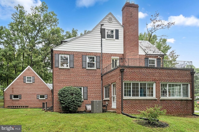 rear view of house featuring a lawn and central AC unit