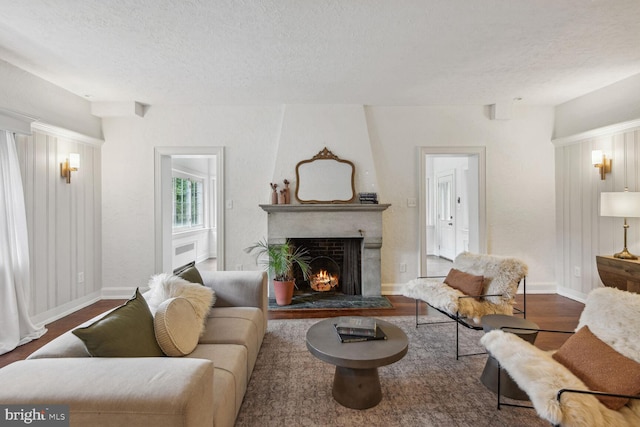 living room featuring a textured ceiling, a fireplace, and dark hardwood / wood-style flooring