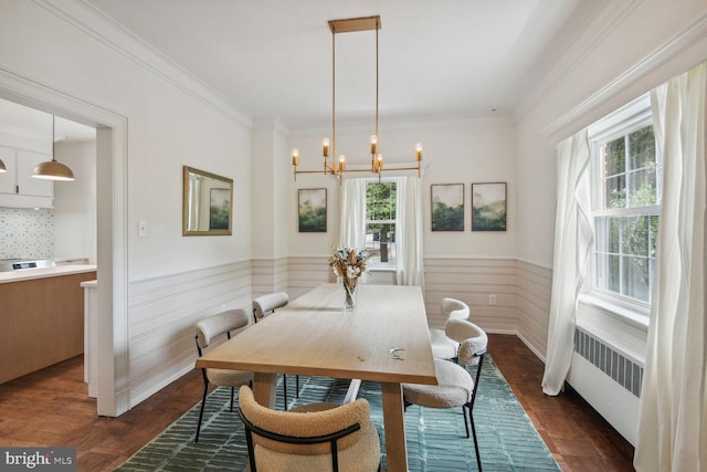 dining area featuring an inviting chandelier, radiator, dark hardwood / wood-style flooring, and crown molding