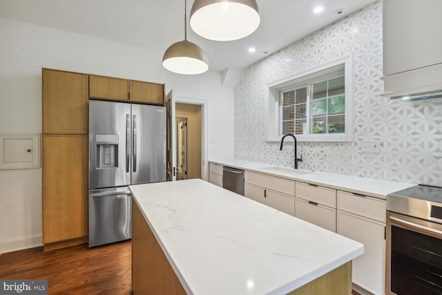 kitchen featuring pendant lighting, sink, backsplash, dark wood-type flooring, and appliances with stainless steel finishes