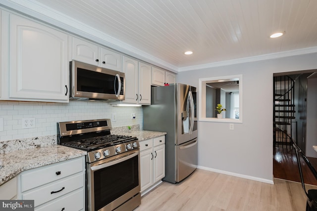 kitchen with white cabinets, appliances with stainless steel finishes, light hardwood / wood-style flooring, and crown molding