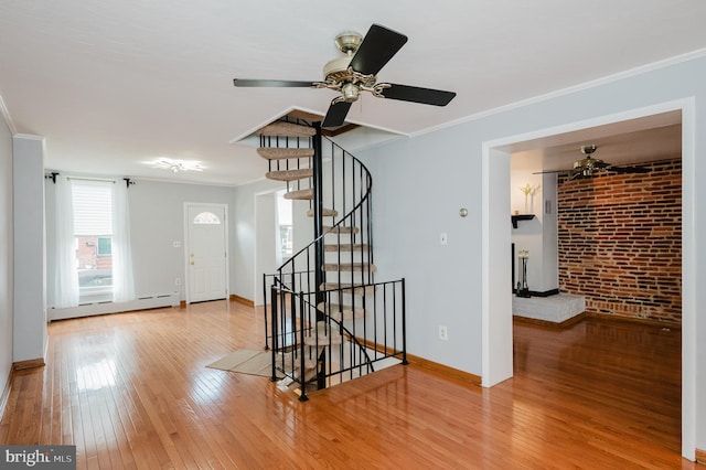 entrance foyer with crown molding, a baseboard radiator, and hardwood / wood-style flooring