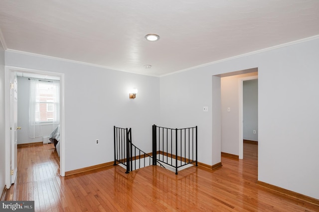 empty room featuring wood-type flooring and ornamental molding