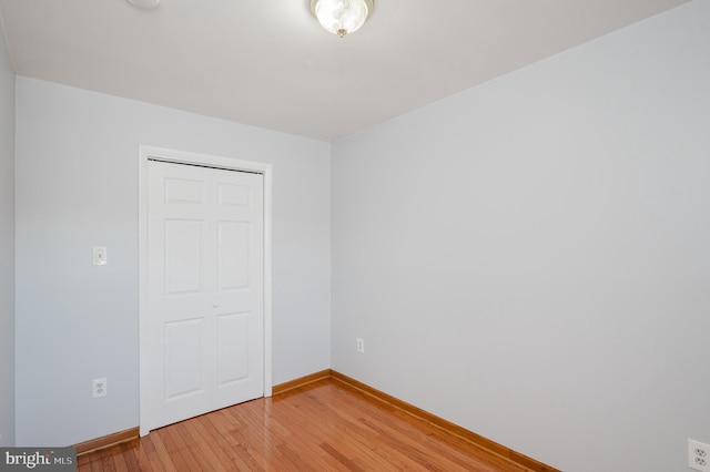 unfurnished bedroom featuring hardwood / wood-style floors and a closet