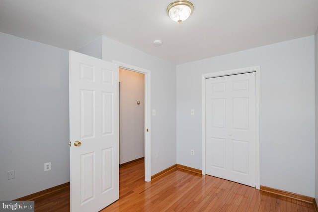 unfurnished bedroom with a closet and hardwood / wood-style floors