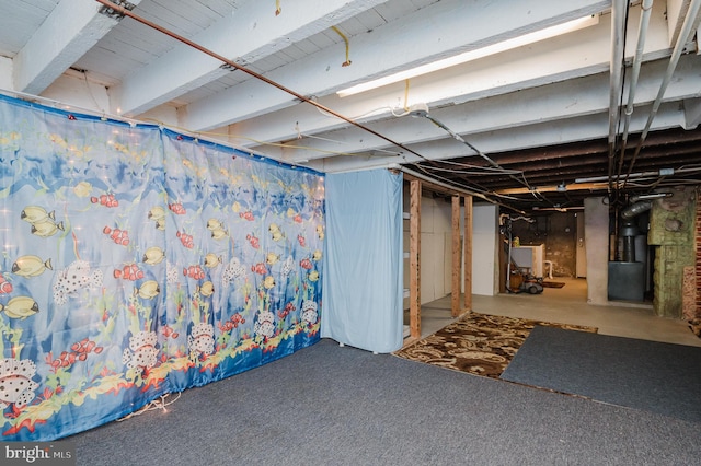 basement featuring carpet and heating unit