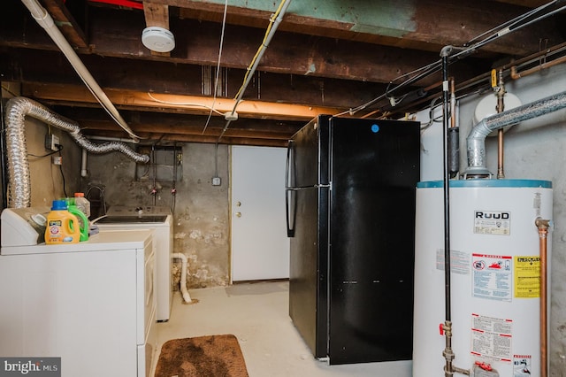 basement with water heater, black fridge, and washer and clothes dryer