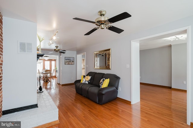 living room featuring light wood-type flooring and ceiling fan