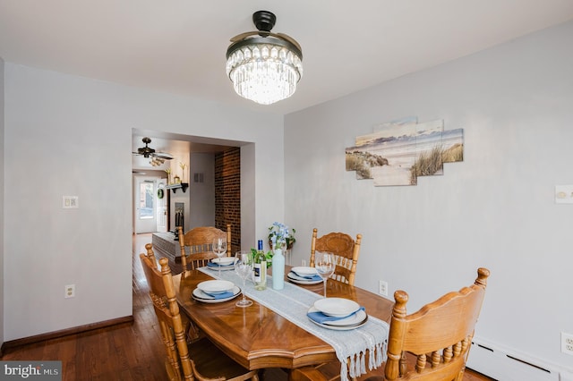 dining room with baseboard heating, dark hardwood / wood-style flooring, and ceiling fan with notable chandelier