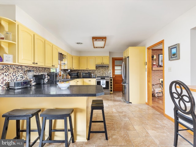 kitchen featuring stainless steel appliances, sink, light brown cabinets, backsplash, and light wood-type flooring