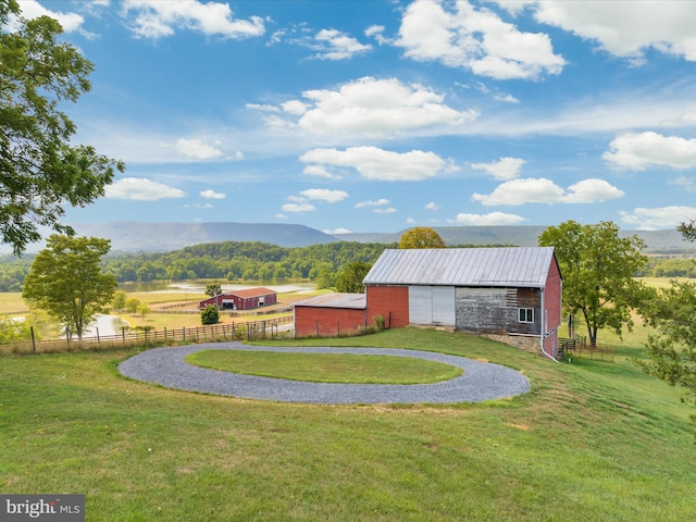 view of yard with an outdoor structure, a mountain view, and a rural view