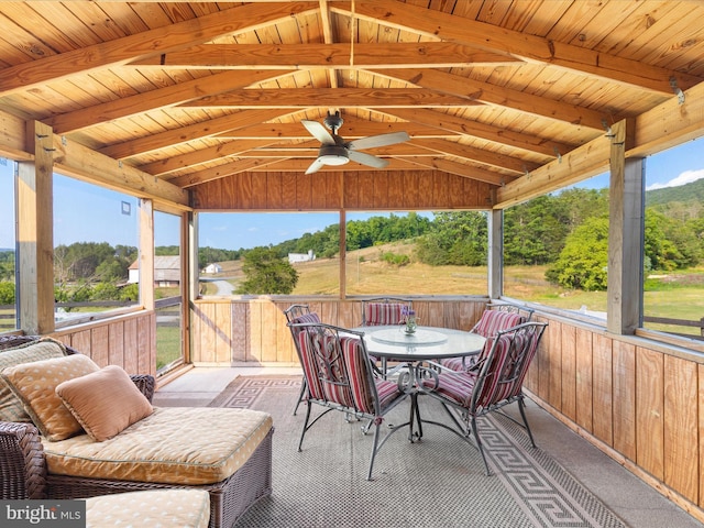 sunroom / solarium featuring wood ceiling, ceiling fan, a wealth of natural light, and vaulted ceiling with beams