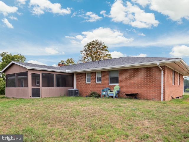 back of property with cooling unit, a sunroom, and a yard