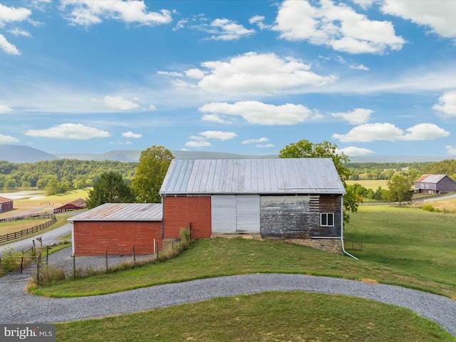 view of outdoor structure with a mountain view and a yard