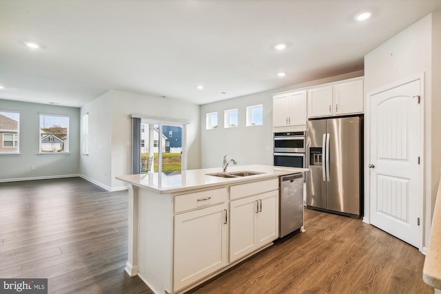 kitchen with dark wood-type flooring, sink, white cabinetry, appliances with stainless steel finishes, and an island with sink