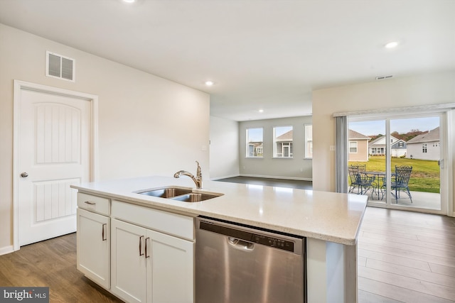 kitchen with an island with sink, sink, white cabinets, hardwood / wood-style flooring, and stainless steel dishwasher