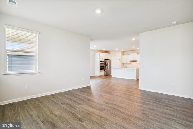 unfurnished living room featuring dark wood-type flooring