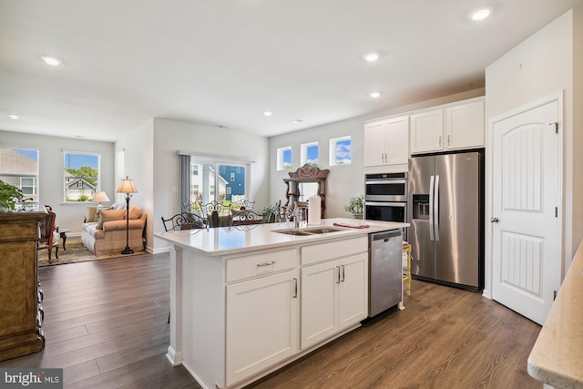 kitchen featuring stainless steel appliances, a kitchen island with sink, white cabinets, and sink