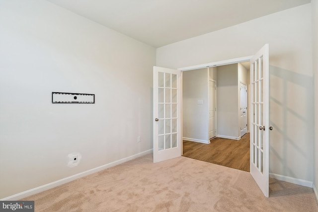 unfurnished bedroom featuring french doors and light colored carpet