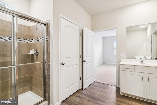 bathroom with hardwood / wood-style flooring, vanity, and walk in shower