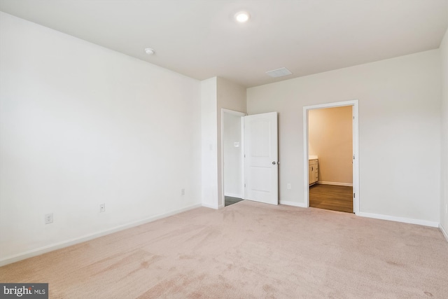 unfurnished bedroom with connected bathroom and carpet flooring