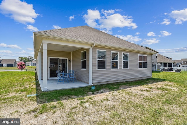 rear view of property with a lawn and a patio