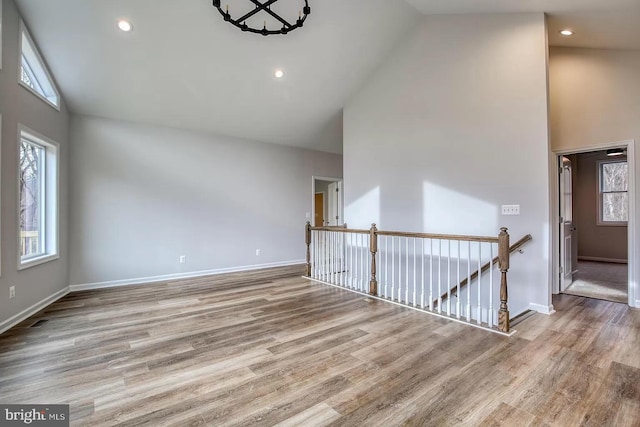 spare room with high vaulted ceiling and hardwood / wood-style flooring